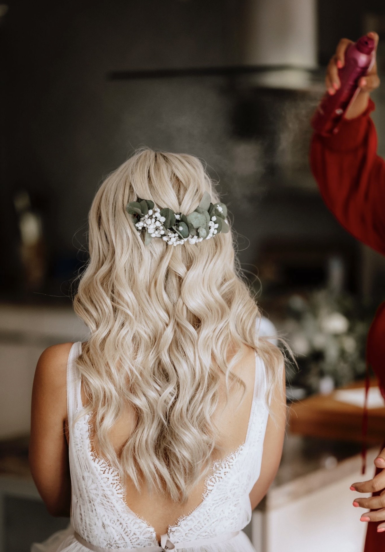 Braut mit langen blonden Wellen und floralem Haarschmuck