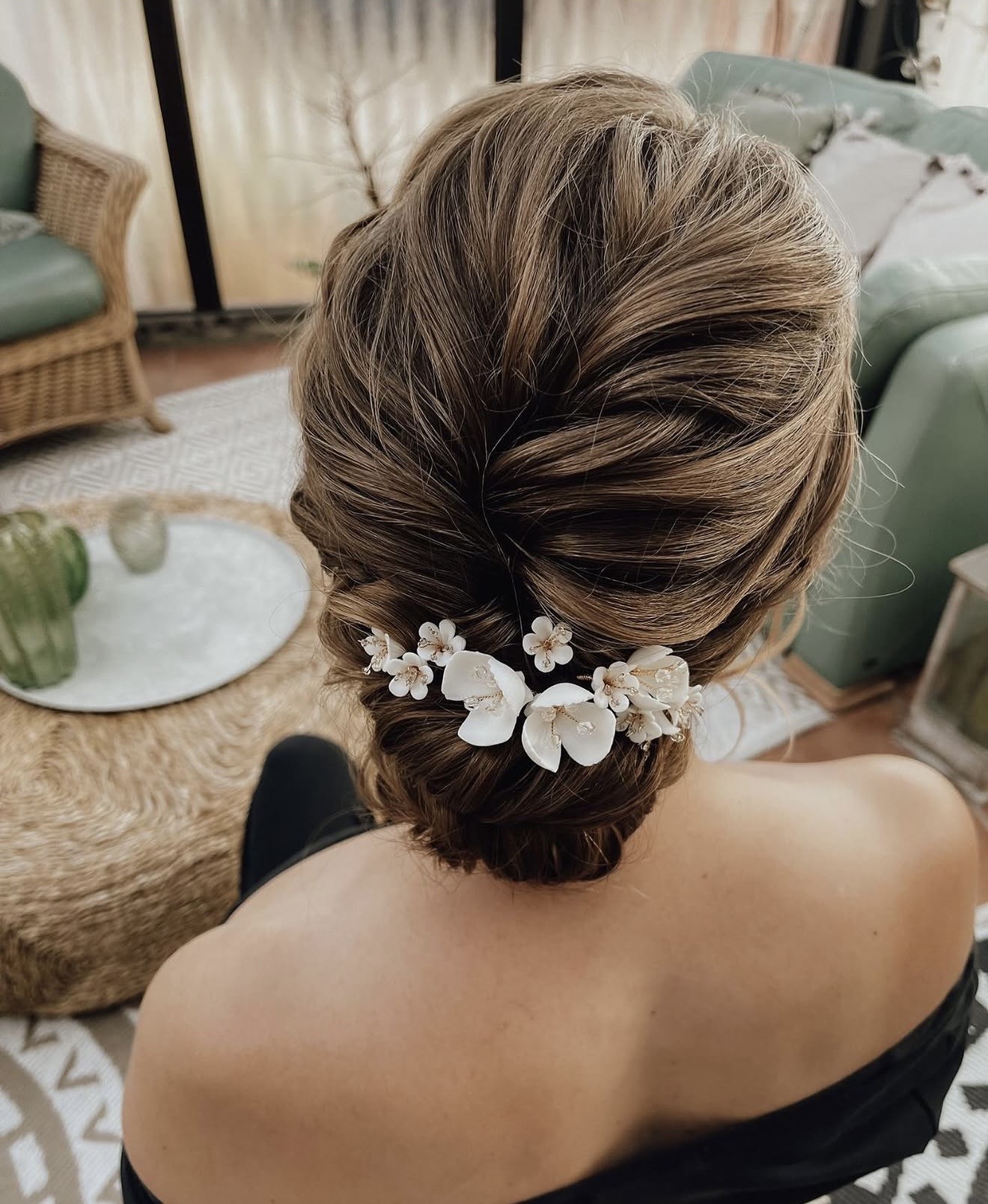 Natürliches Brautstyling mit locker gestecktem Dutt und weißem Blüten-Haarschmuck