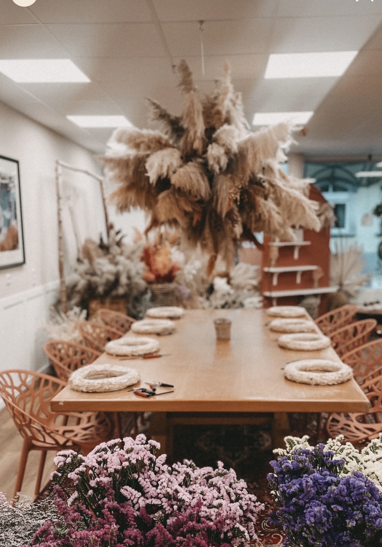 Vorbereiteter Workshop-Tisch mit Blumen und Arbeitsplätzen